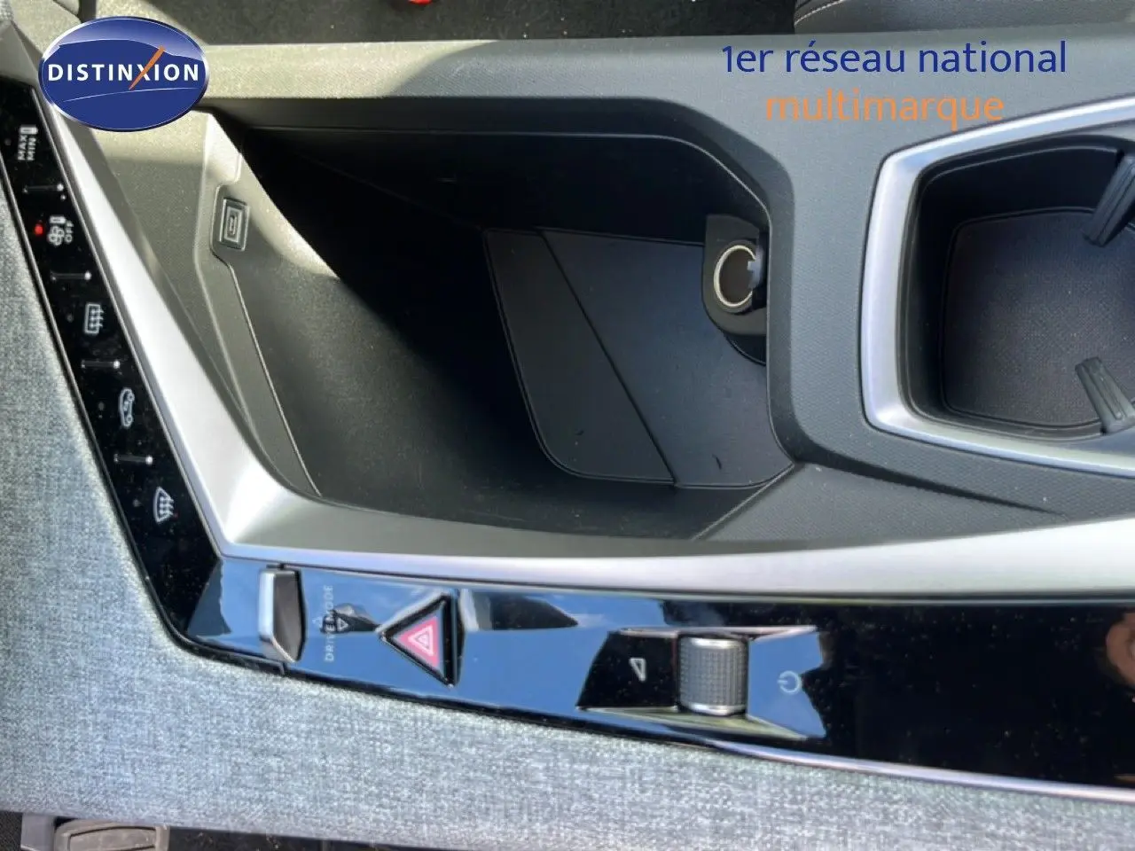 Gros plan sur la console centrale intérieure du Peugeot 5008 gris Artense, montrant les commandes et un espace de rangement.