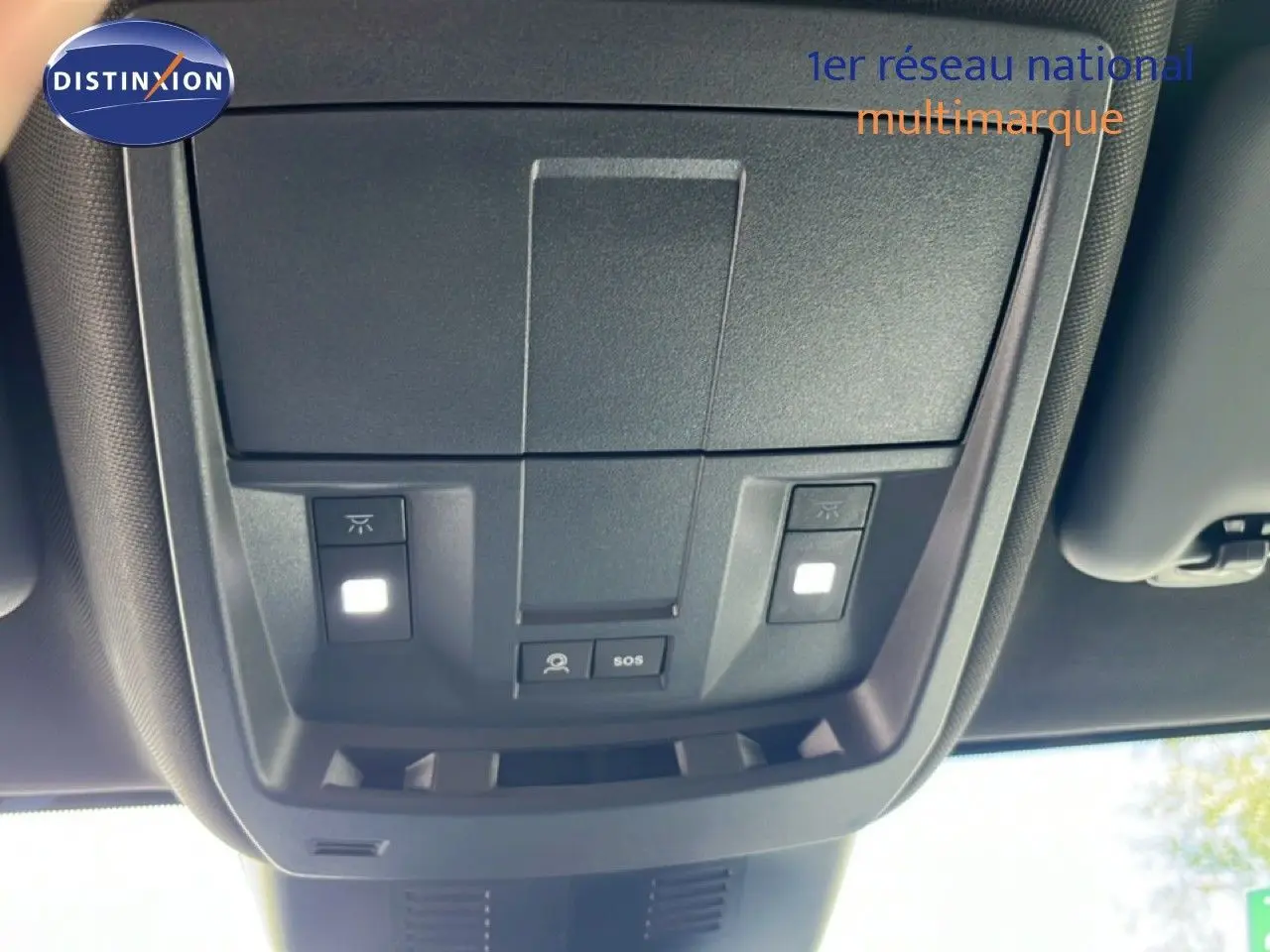 Vue intérieure en gros plan du plafonnier avec commandes d’éclairage et bouton SOS du Peugeot 5008 gris Artense 2025.