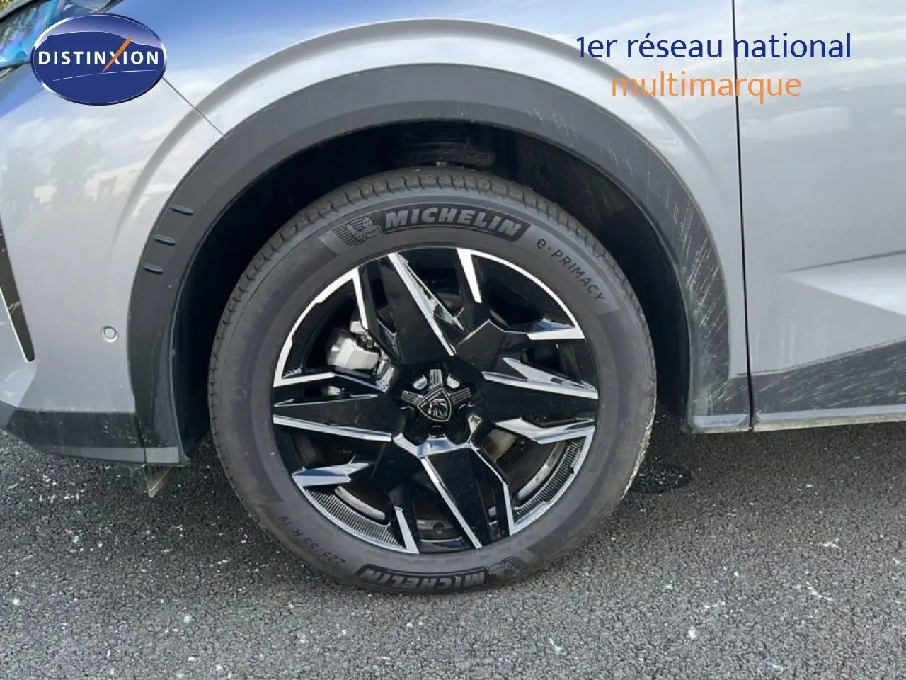 Gros plan sur la roue avant gauche du Peugeot 5008 gris Artense avec jante noire et détails chromés.