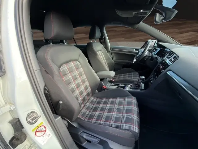 Vue intérieure avant de la Volkswagen Golf GTI Performance 2019, volant cuir alu multifonctions et sièges à motif tartan rouge et gris.