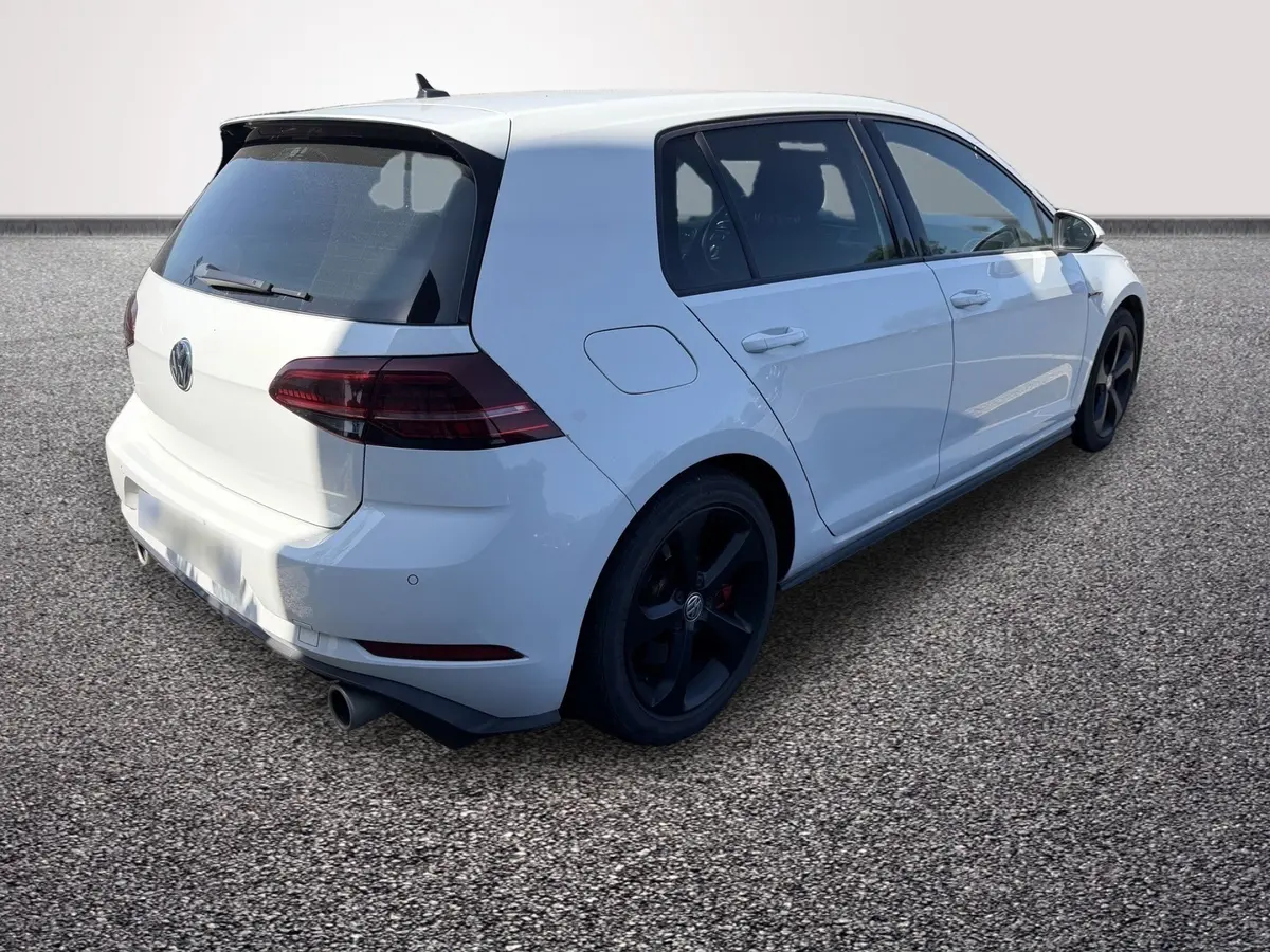 Volkswagen Golf GTI Performance blanche vue 3/4 arrière droit avec jantes noires et double sortie d’échappement.