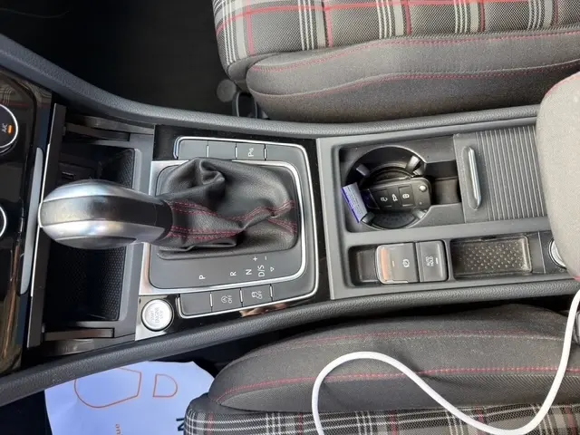 Vue rapprochée de la console centrale de la Volkswagen Golf GTI Performance 2019, avec levier de vitesse DSG7 et clé dans le porte-gobelet.