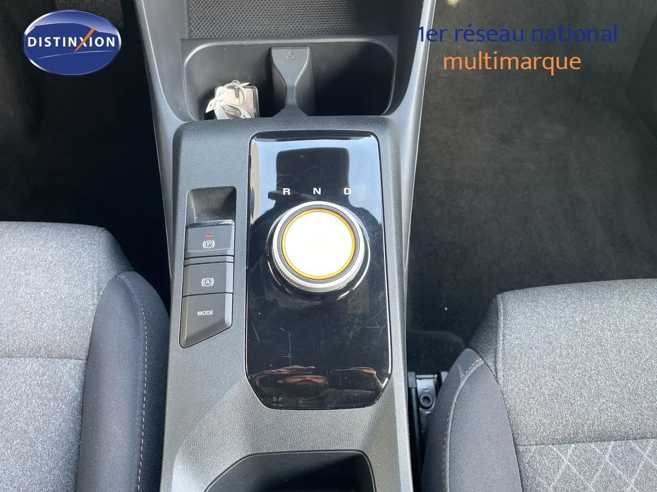 Vue plongeante sur la console centrale du MG3 2025, avec sélecteur rotatif de boîte auto et sièges tissu gris.