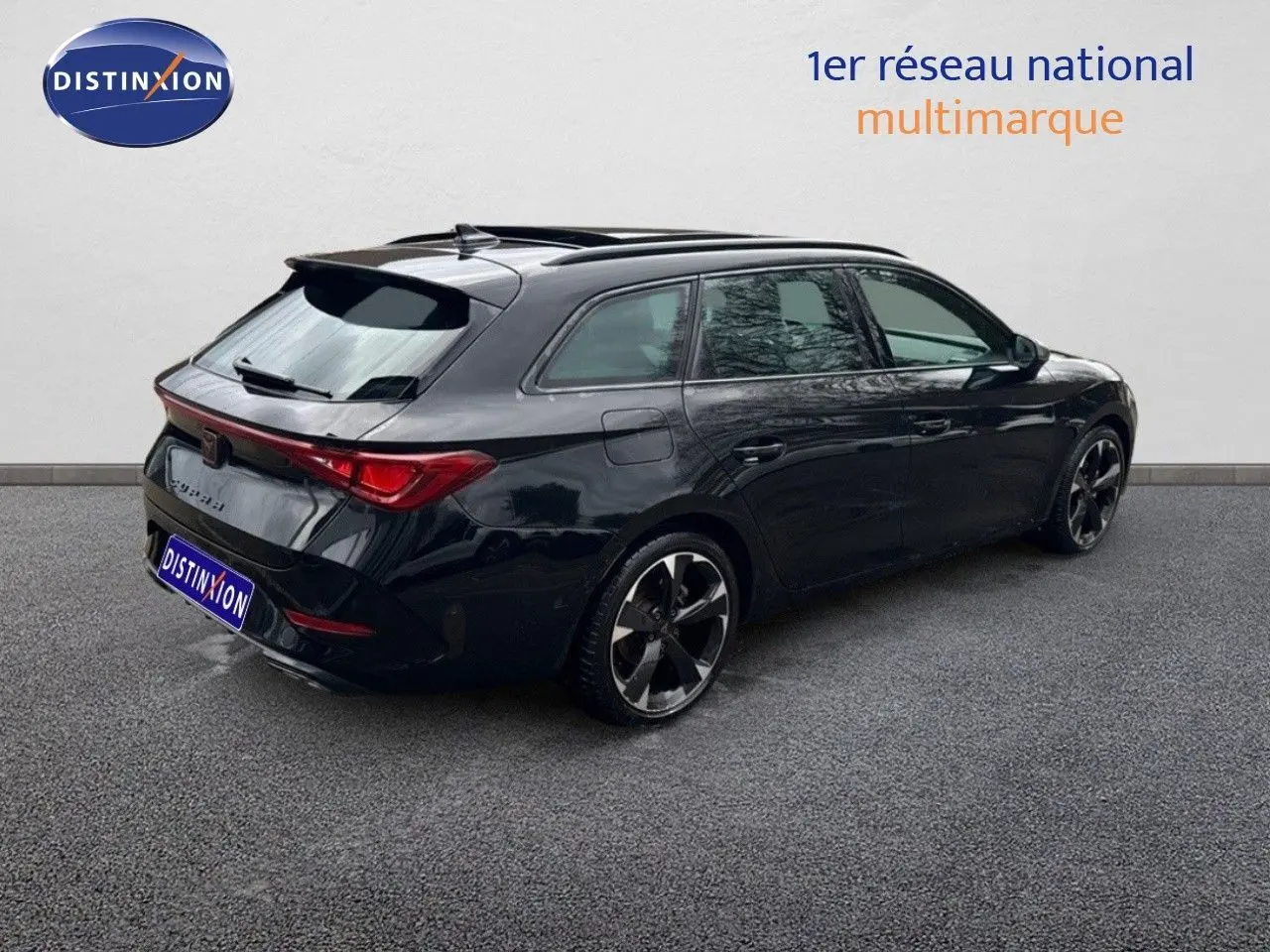 Vue 3/4 arrière droite d'une CUPRA LEON ST noire Midnight Metal avec jantes bi-ton et toit ouvrant.