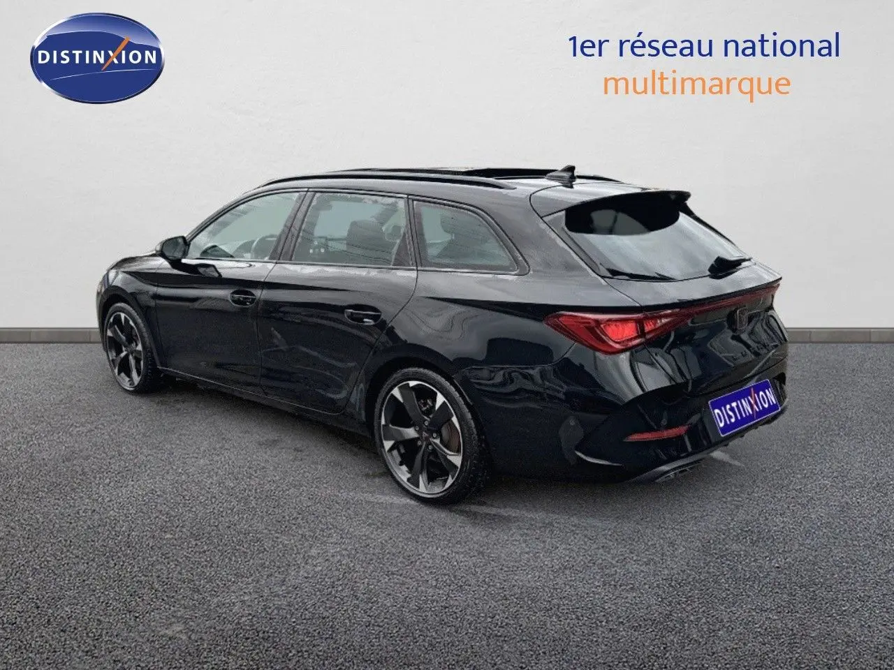 Vue 3/4 arrière droite d'une CUPRA LEON ST noire Midnight Metal avec jantes bi-ton et feux LED distinctifs.