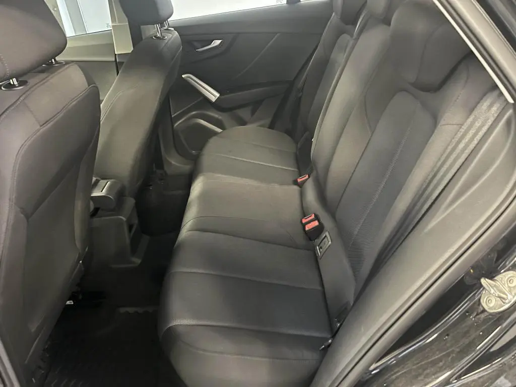 Vue intérieure côté droit des sièges arrière noirs en tissu de l'Audi Q2 Business line 2022 avec accoudoir central avant visible.