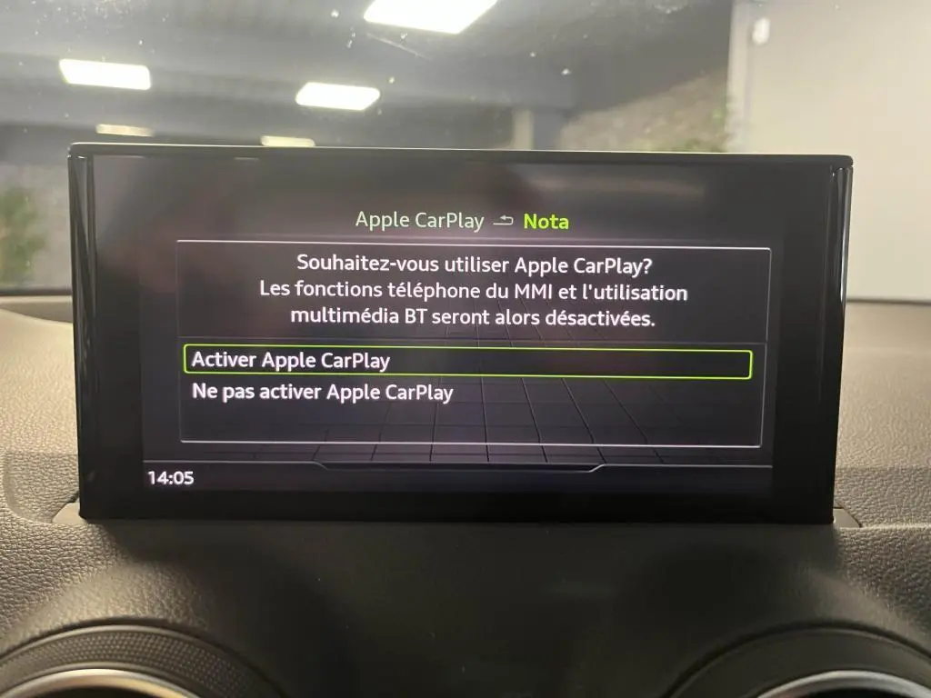 Écran central de l'Audi Q2 2022 affichant le menu d'activation d'Apple CarPlay dans l'habitacle noir.