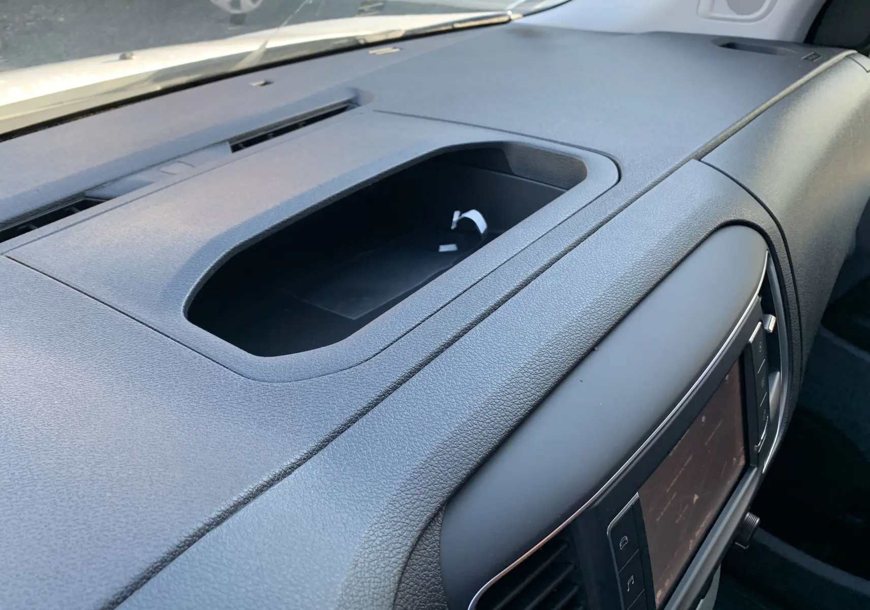 Tableau de bord noir vu de près côté passager du Fiat Scudo Combi électrique 2022 avec écran tactile intégré.