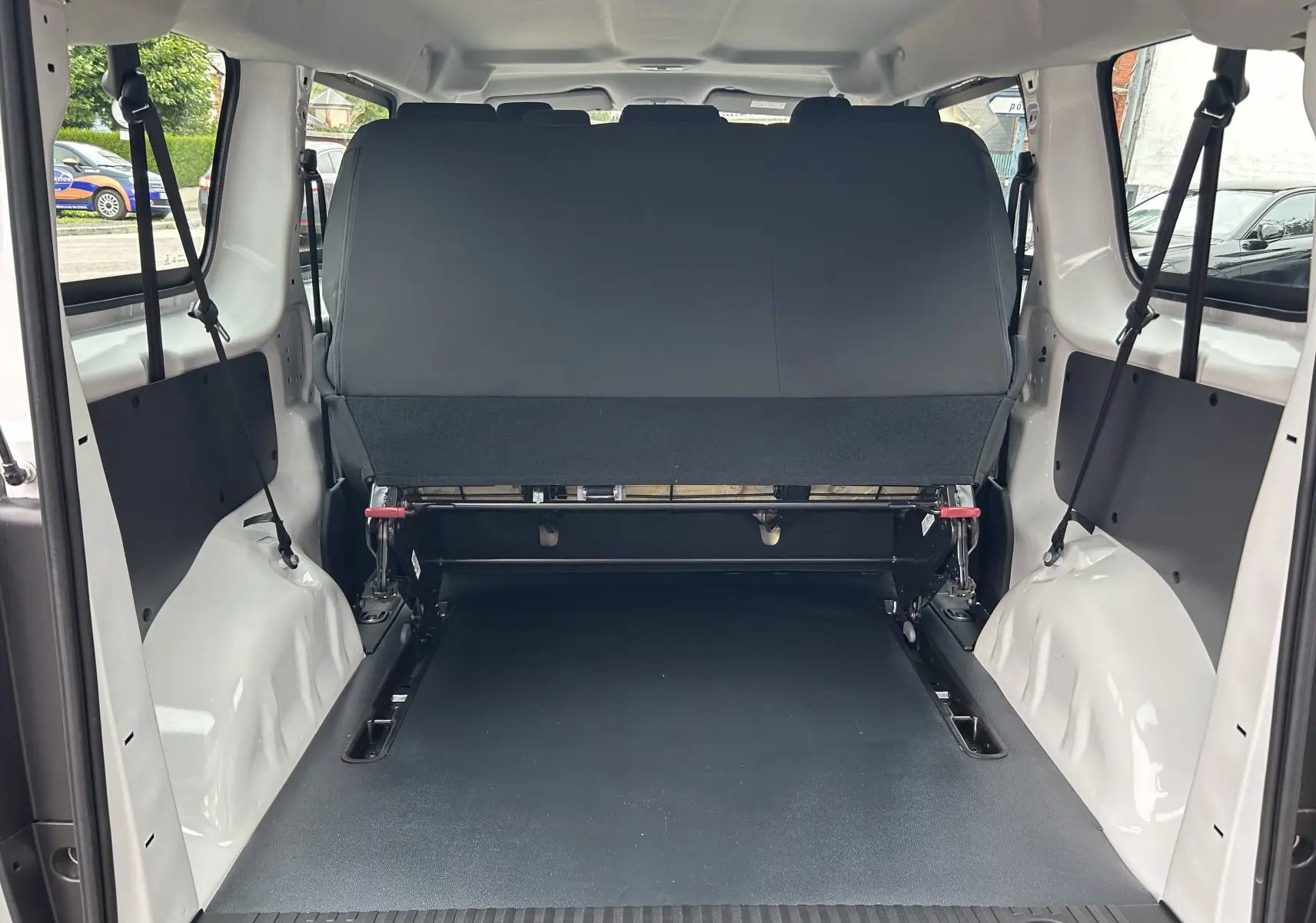 Vue arrière de l'intérieur du FIAT Scudo Combi blanc 2022, montrant la banquette arrière rabattue et l'espace de chargement.