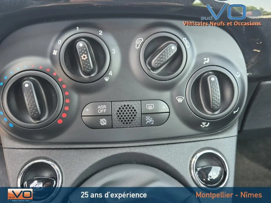 Tableau de bord noir de la Fiat 500C 2024 avec commandes manuelles de climatisation et ventilation visibles.