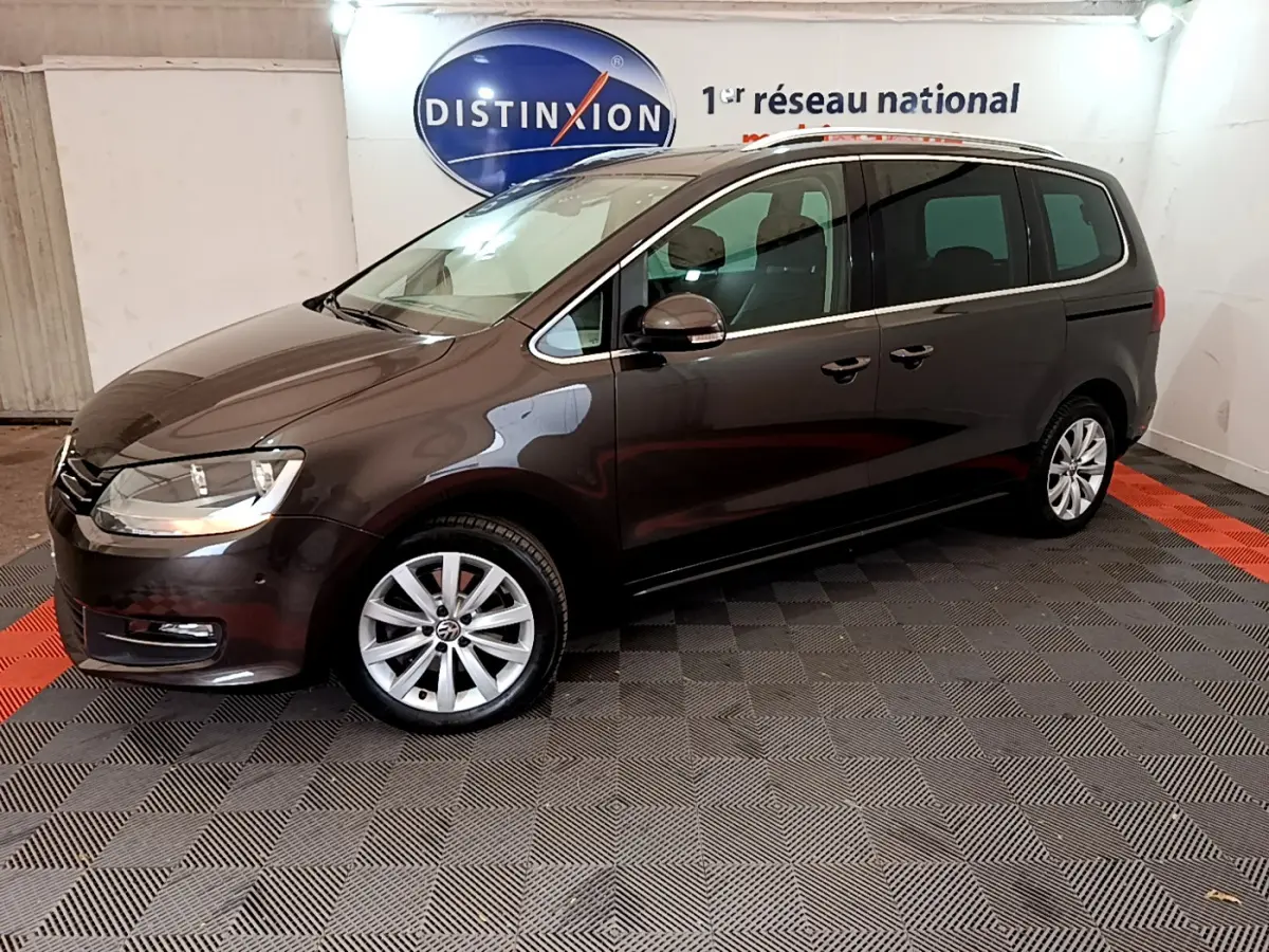 Volkswagen Sharan marron vue de profil côté gauche dans un showroom avec jantes alliage et vitres teintées.