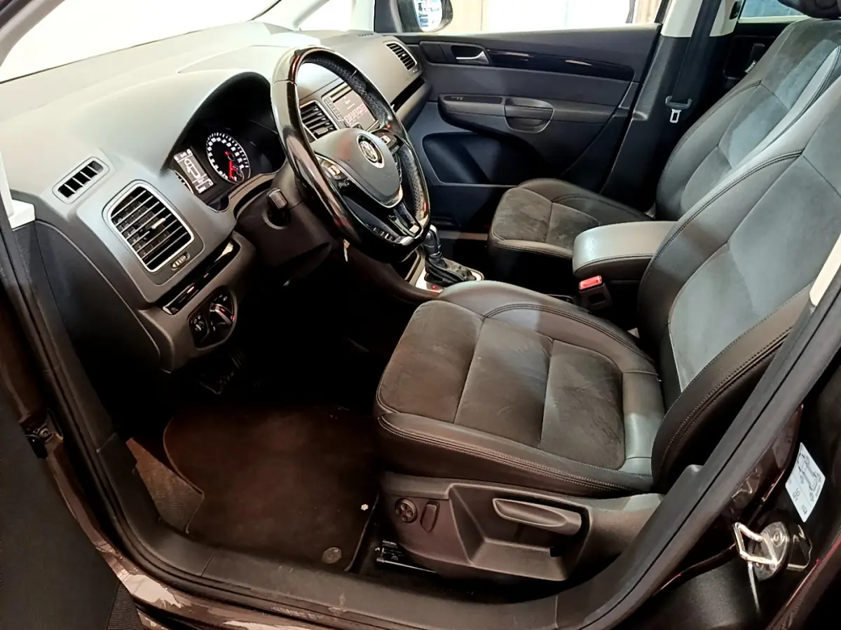 Intérieur avant droit du Volkswagen Sharan 2017 marron, sièges cuir et alcantara, volant multifonctions et tableau de bord visible.