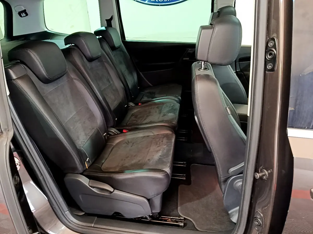 Vue latérale intérieure sur les sièges en cuir noir de la 2ème rangée du Volkswagen Sharan marron 2017.