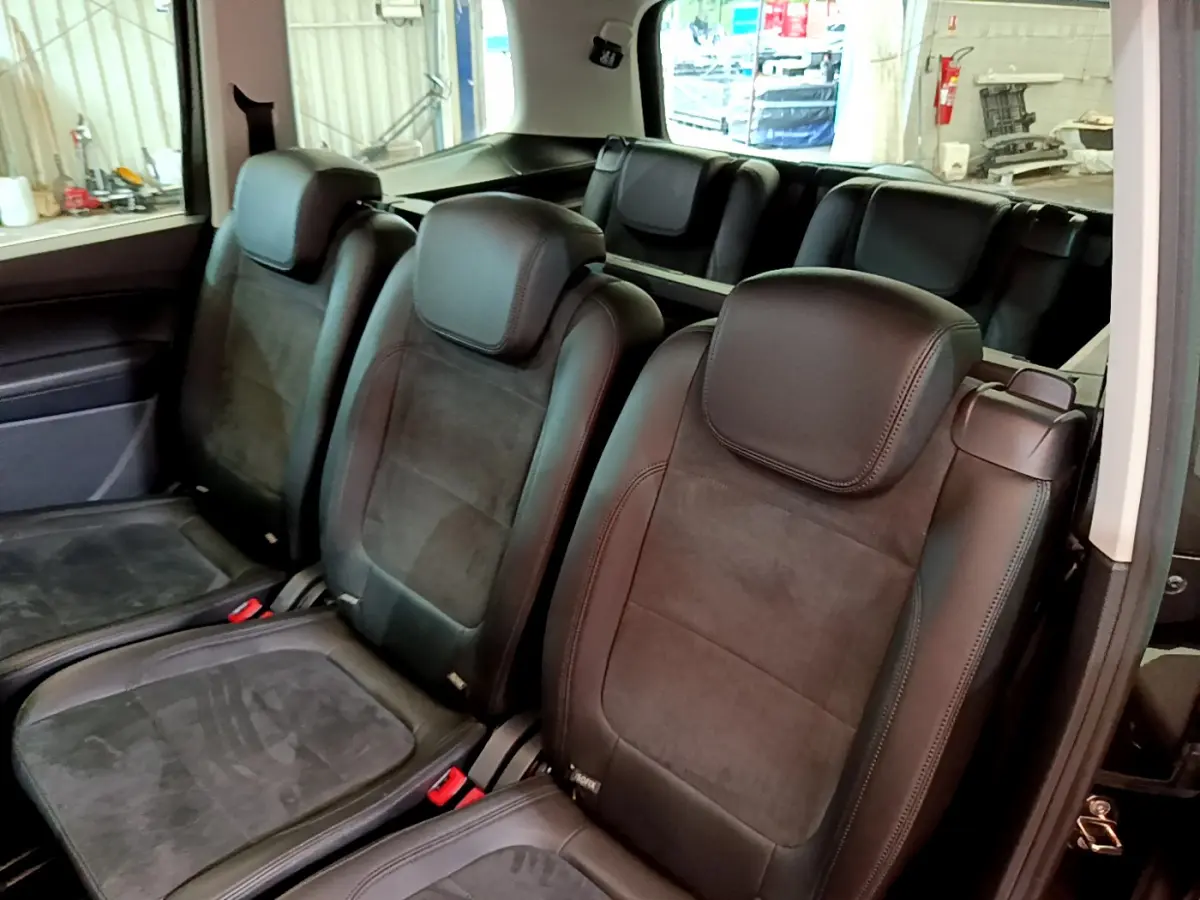 Vue intérieure montrant les sièges individuels noirs de la 2e et 3e rangée du Volkswagen Sharan 2017.