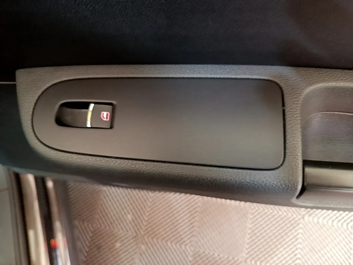 Gros plan sur le bouton de verrouillage des portes dans la portière intérieure d’un Volkswagen Sharan 2017 marron.