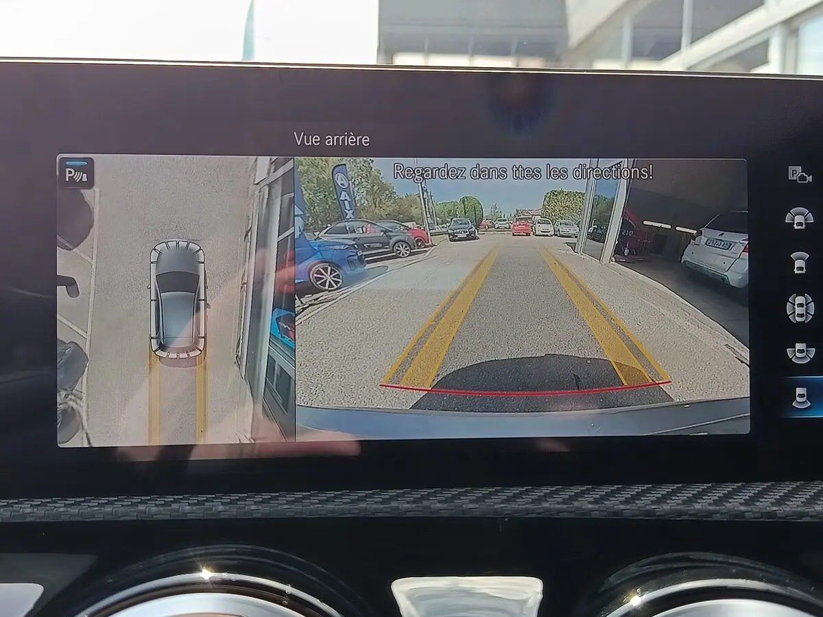 Écran intérieur affichant la caméra de recul et vue 360° d'une Mercedes Classe A gris clair en marche arrière.
