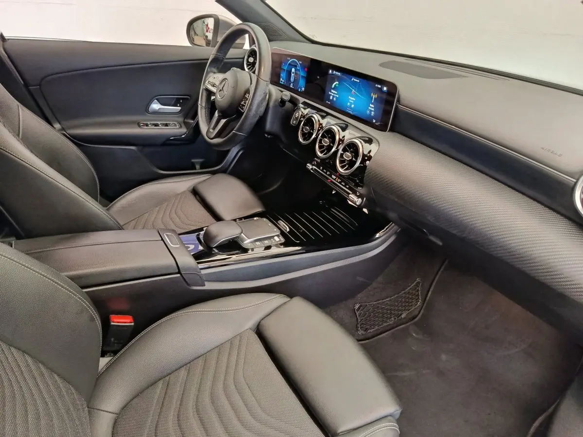 Vue intérieure côté conducteur de la Mercedes Classe A 180 Business Line 2020 avec tableau de bord numérique et volant cuir multifonctions.