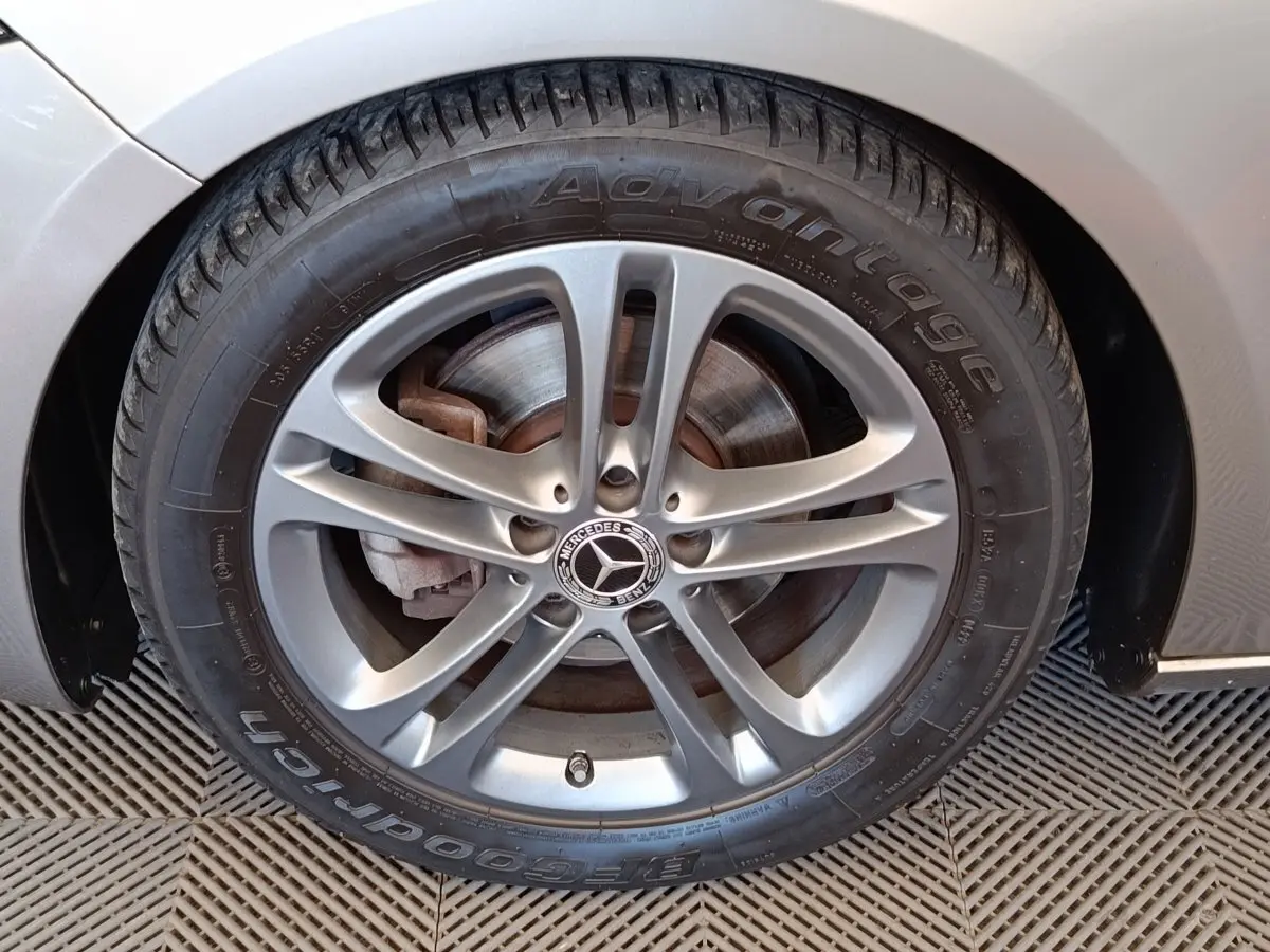 Gros plan sur la roue avant droite gris clair d'une Mercedes Classe A 180 Business Line avec jante alliage.