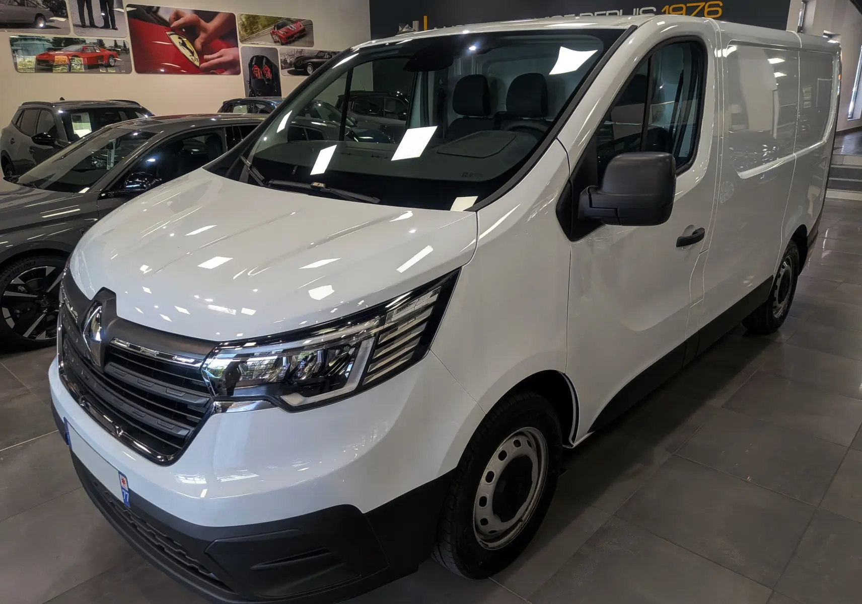 Vue 3/4 avant droit du Renault Trafic Fourgon blanc minéral 2024, avec calandre chromée et optiques modernes.