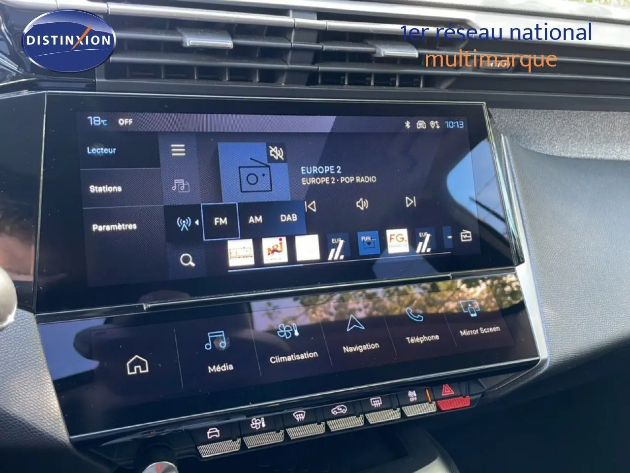 Vue rapprochée de l’écran tactile central du tableau de bord de la Peugeot 308 SW gris Artense, affichant la radio FM.