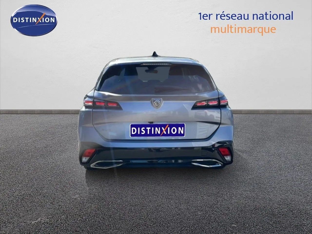 Vue arrière d'une Peugeot 308 SW Hybrid gris Artense métal, mettant en valeur ses feux arrière étirés et son double échappement intégré.