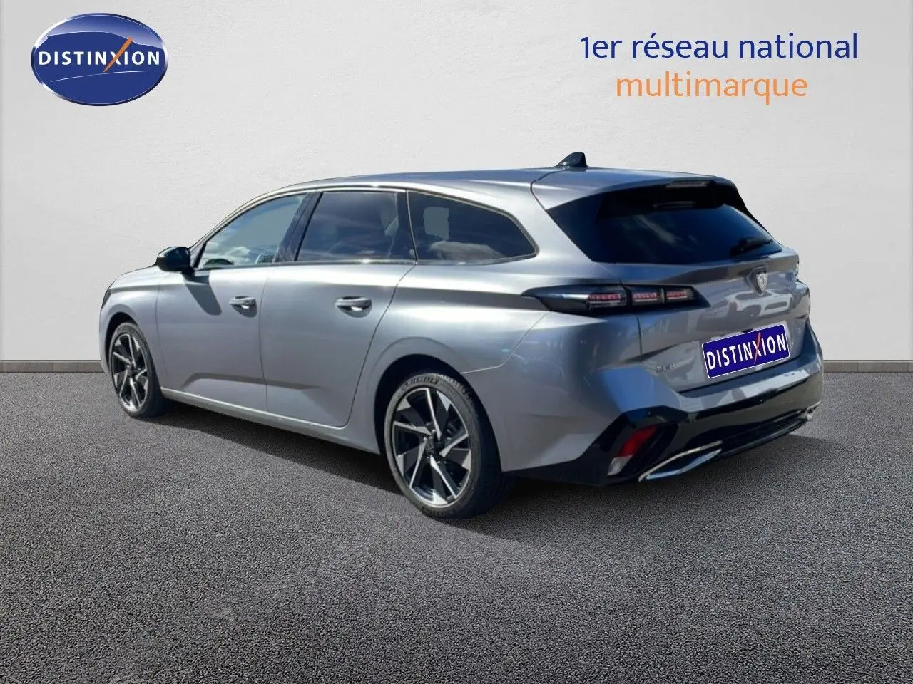 Vue 3/4 arrière droite d'une Peugeot 308 SW Hybrid gris Artense métallisé avec jantes alliage et vitres teintées.