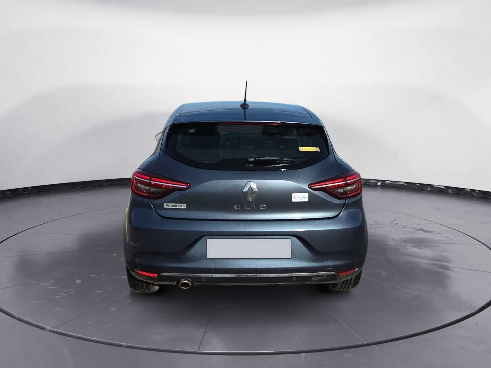Vue arrière d'une Renault Clio V gris foncé métallisé, avec feux LED et un seul pot d'échappement visible côté gauche.