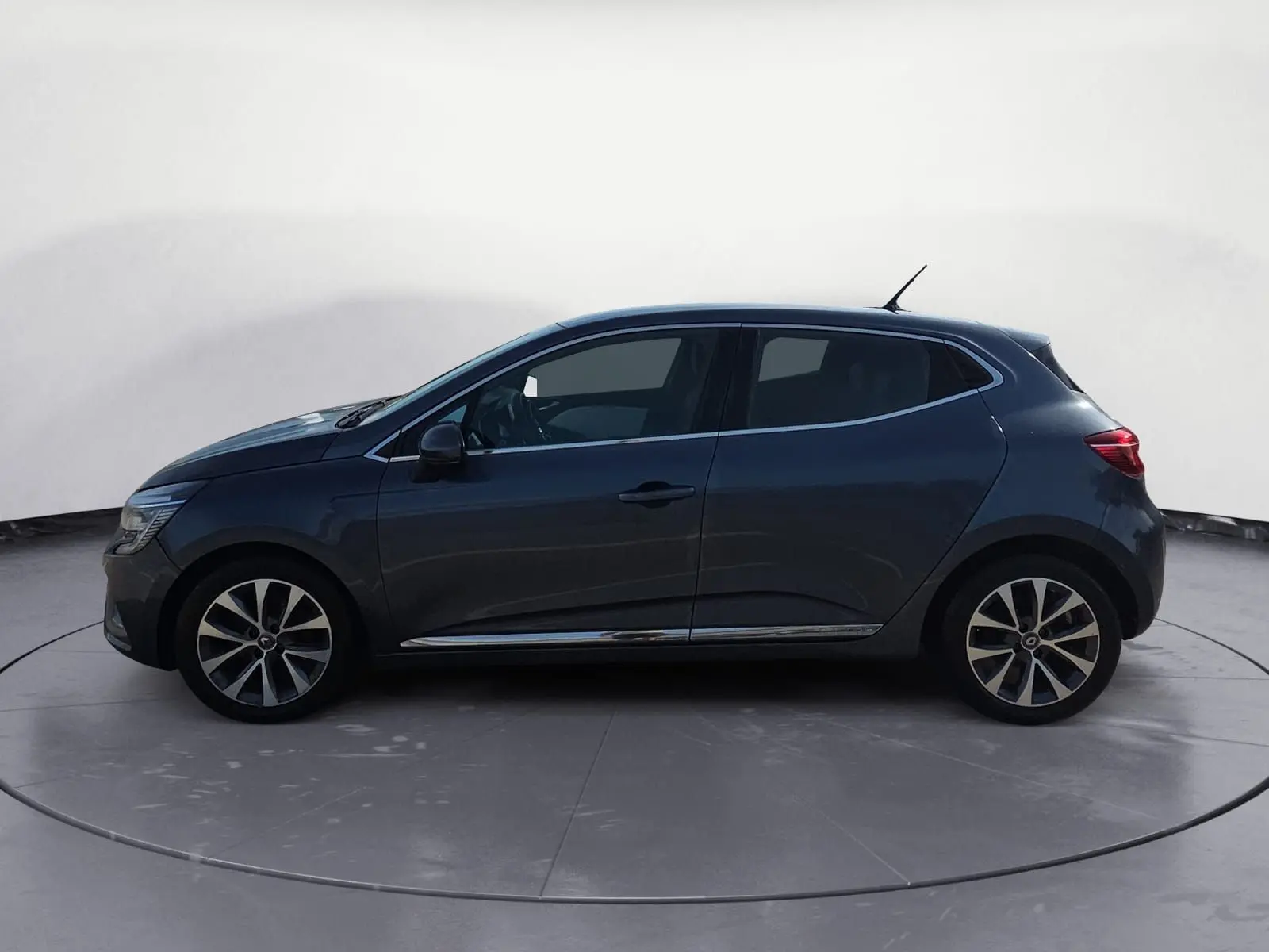 Profil côté gauche d'une Renault Clio V gris foncé métal de 2021 avec jantes alliage et vitres teintées.