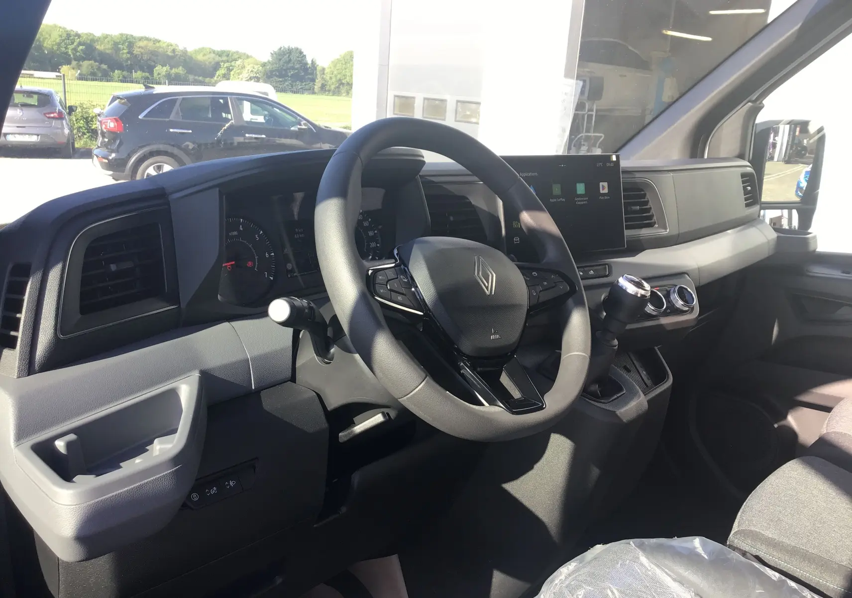 Vue intérieure côté conducteur du Renault Master blanc 2025, avec volant multifonction et écran tactile GPS.