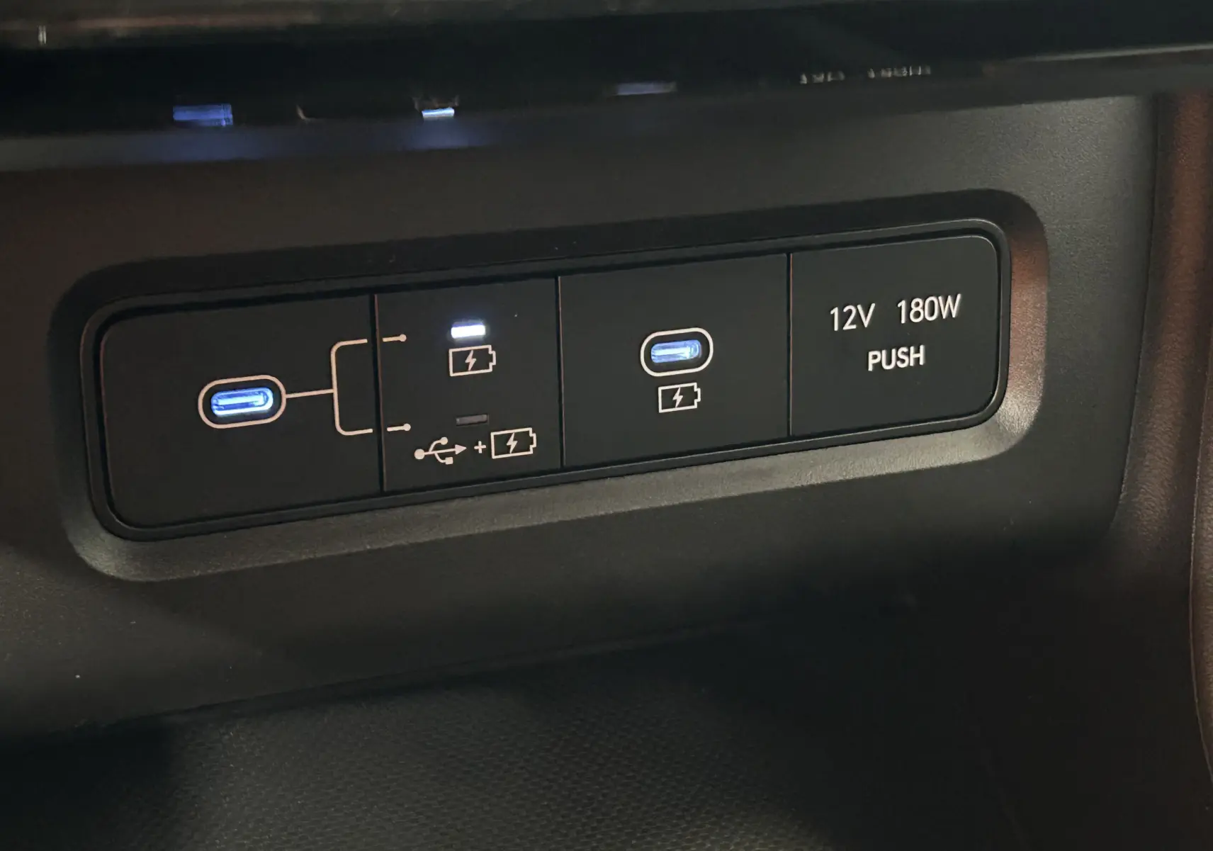 Gros plan sur les ports USB-C et prise 12V du Hyundai Tucson 2025 hybride, finition STYLE en intérieur noir.