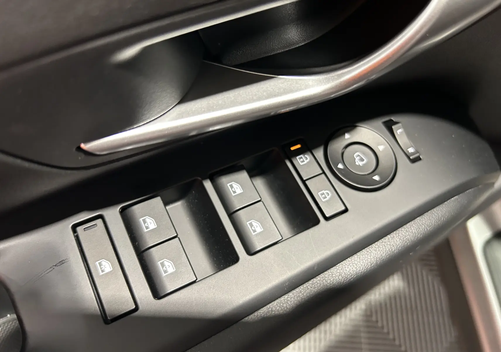 Gros plan sur les commandes des vitres et rétroviseurs côté gauche du Hyundai Tucson 2025 finition Style en intérieur noir.