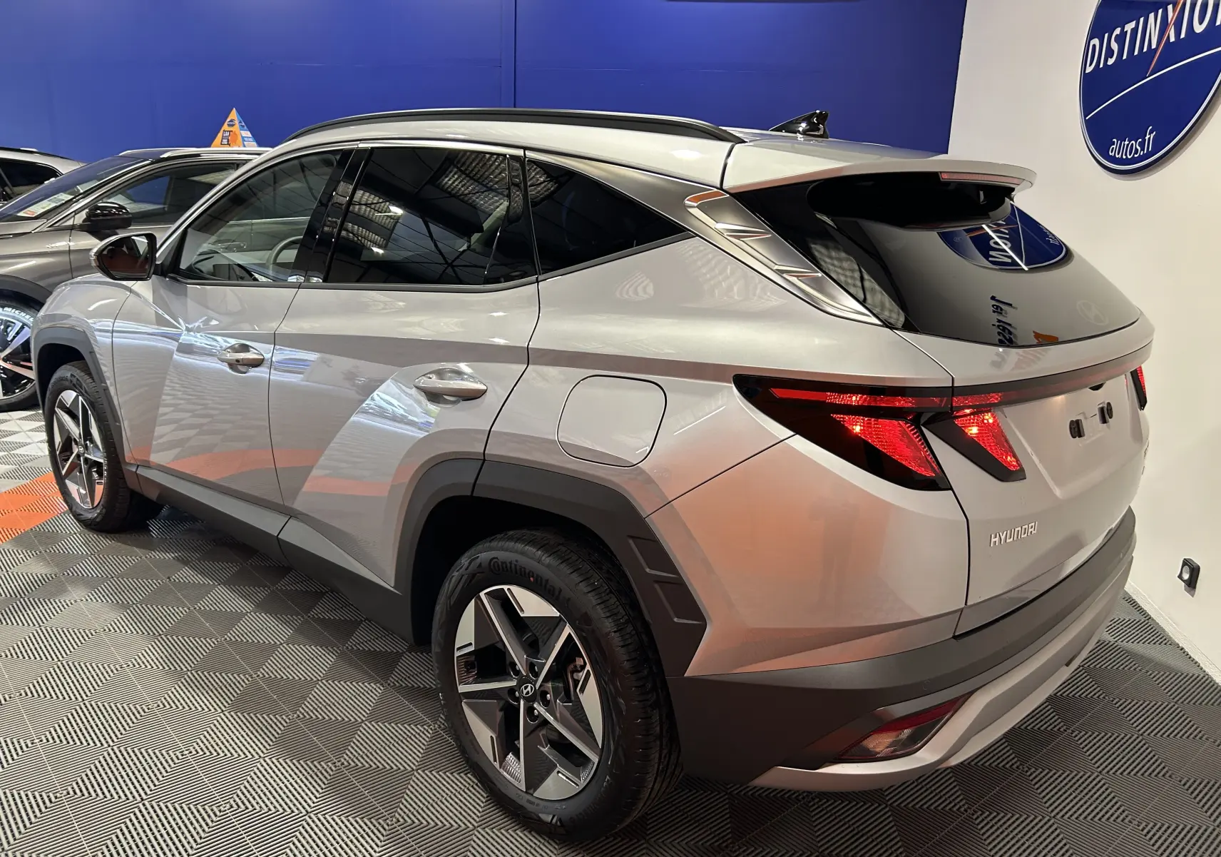 Vue 3/4 arrière droite d'un Hyundai Tucson 2025 Shimmering Silver avec jantes 18 pouces et vitres arrière surteintées.