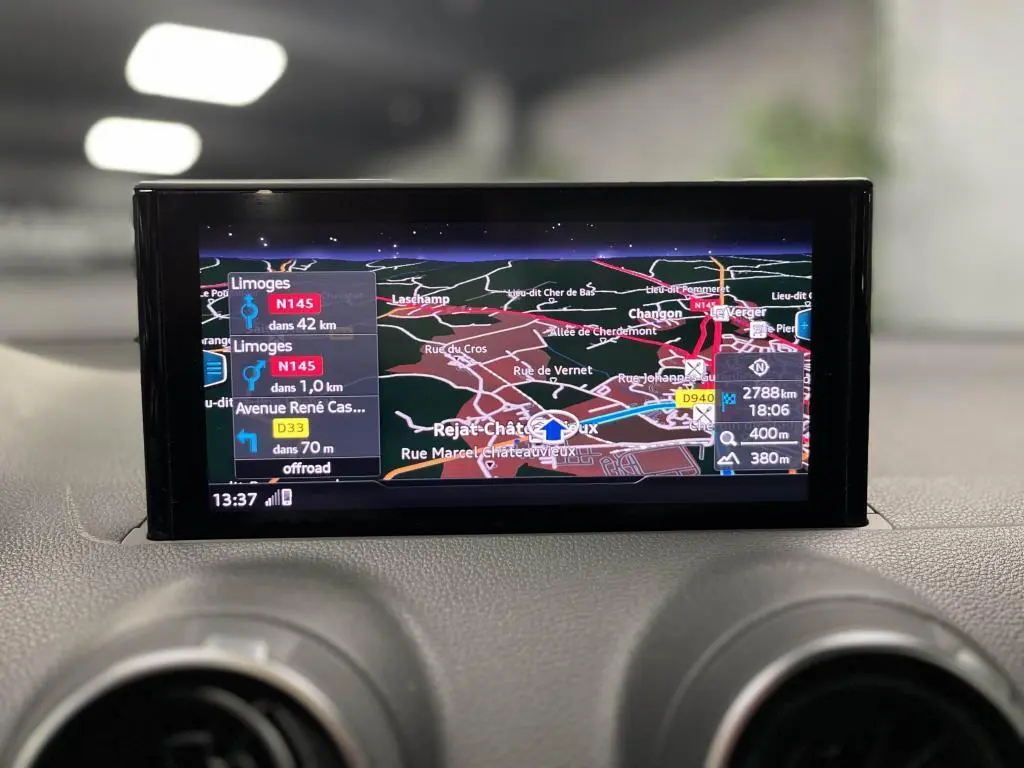 Écran central de navigation de l'Audi Q2 2022 affichant un itinéraire avec carte détaillée et indications routières.