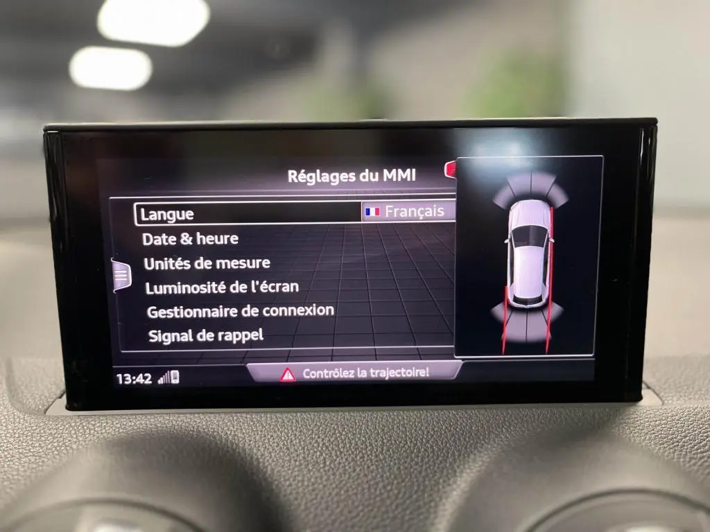 Écran central MMI de l'Audi Q2 noir 2022 affichant les réglages en français avec vue du système de détection de proximité.