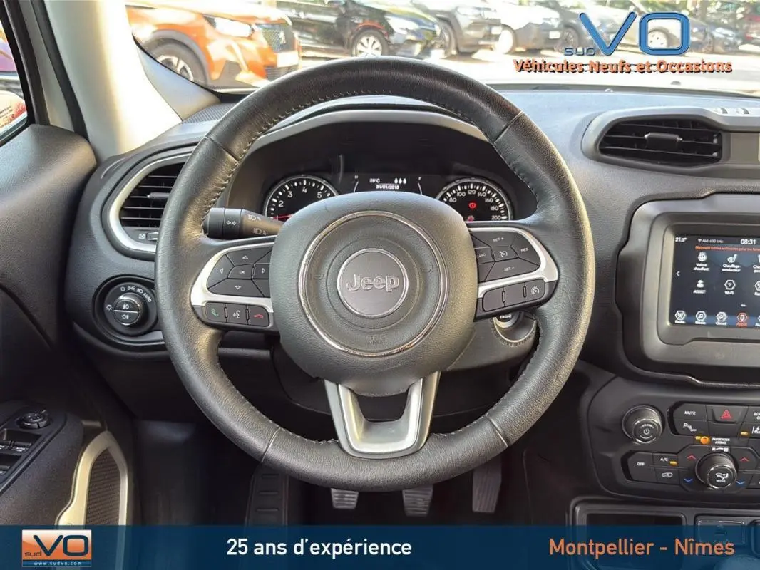 Vue centrée sur le volant cuir du Jeep Renegade blanc, avec tableau de bord et écran tactile visibles.