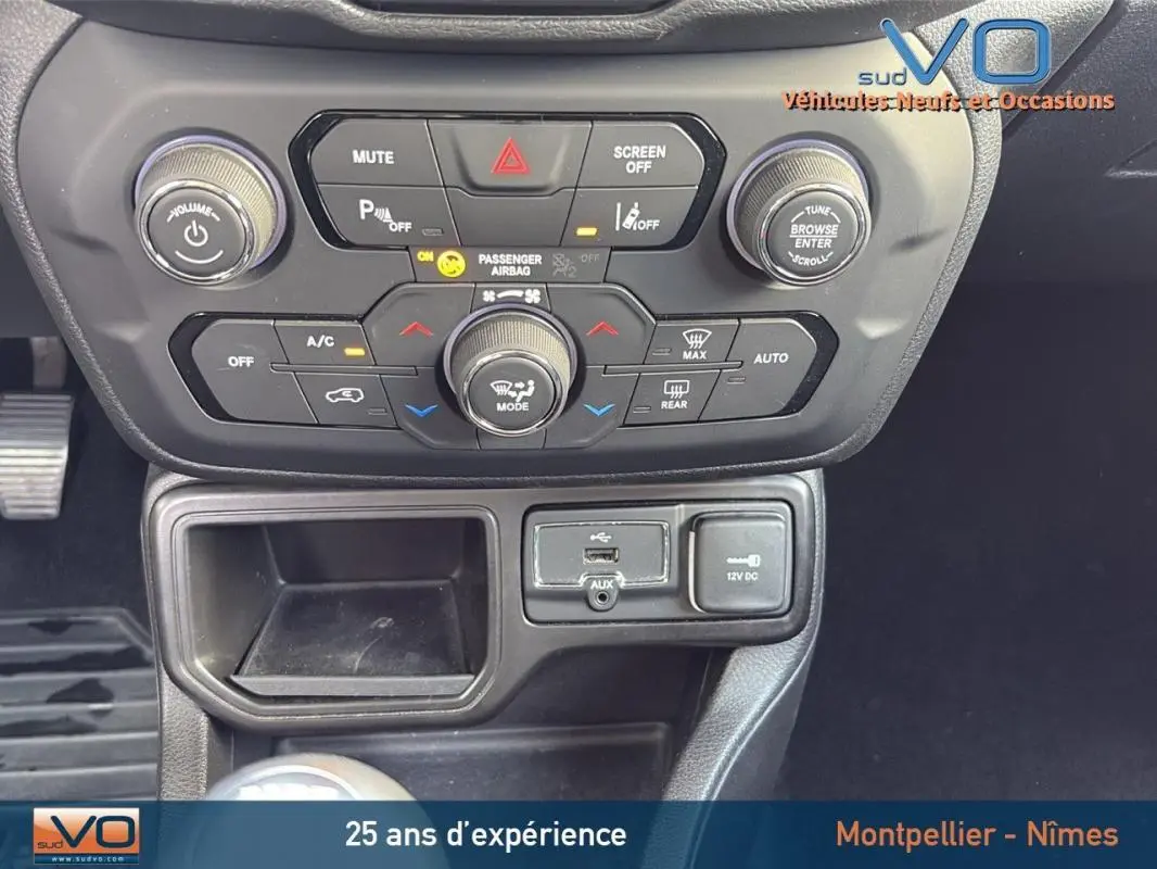 Vue rapprochée de la console centrale du Jeep Renegade blanc 2020, montrant les commandes climatisation et connectivité.