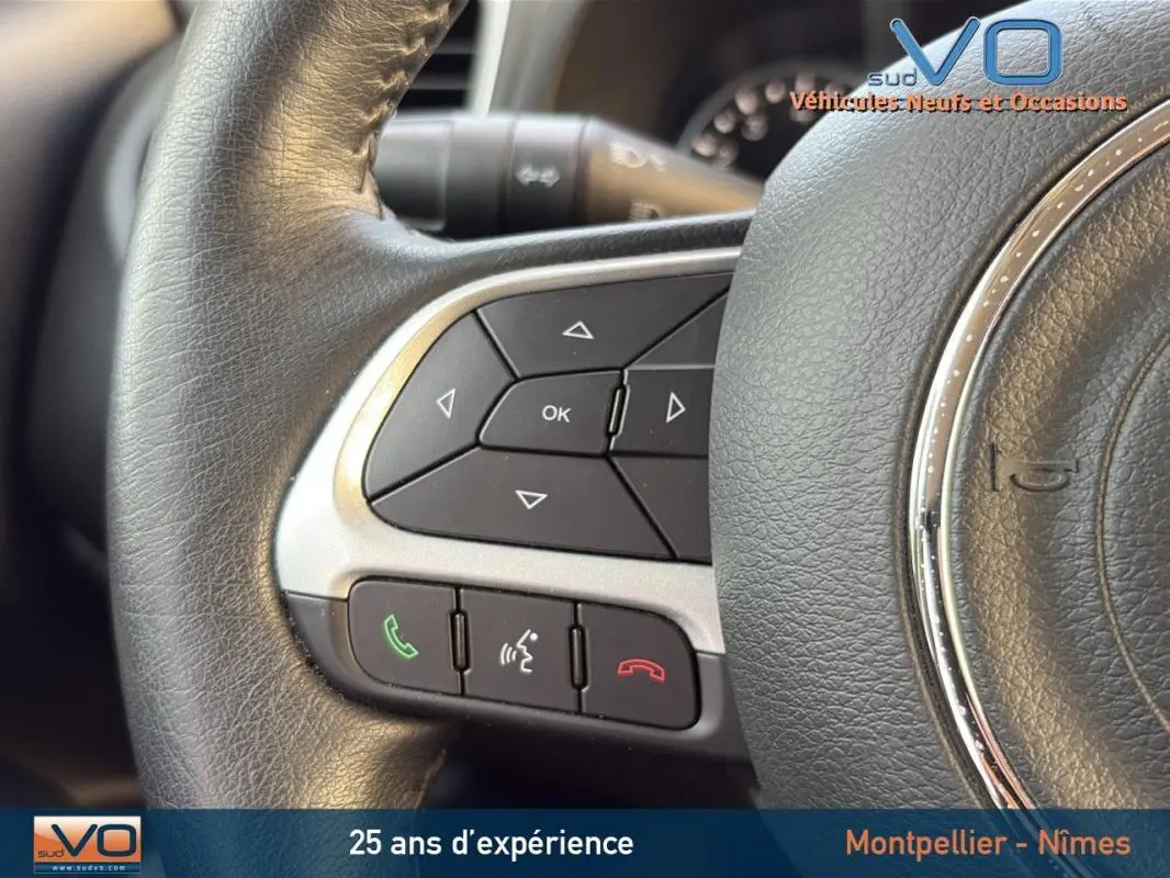 Gros plan sur les commandes multifonctions du volant cuir noir du Jeep Renegade blanc 2020.