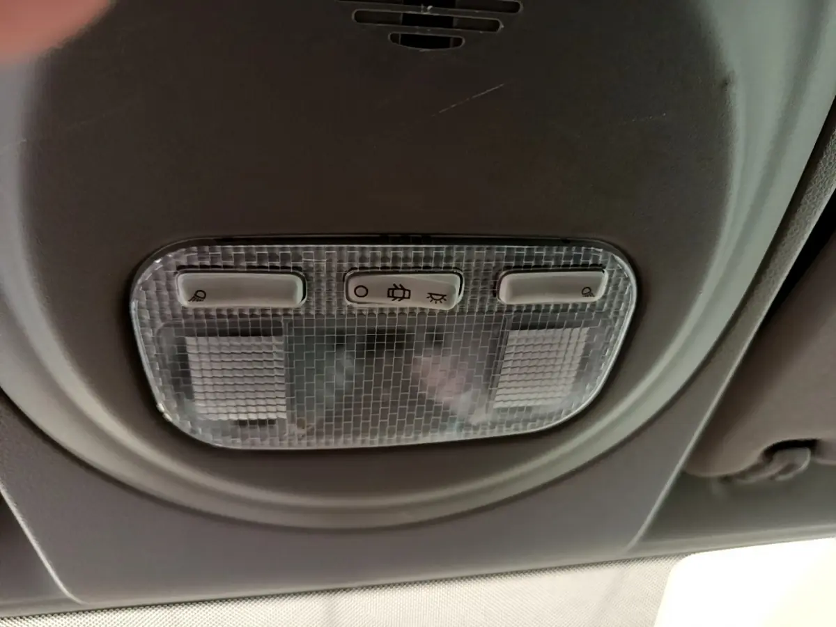 Plafonnier intérieur avec commandes d'éclairage dans une Citroën Berlingo rouge, vue en gros plan depuis l'habitacle.