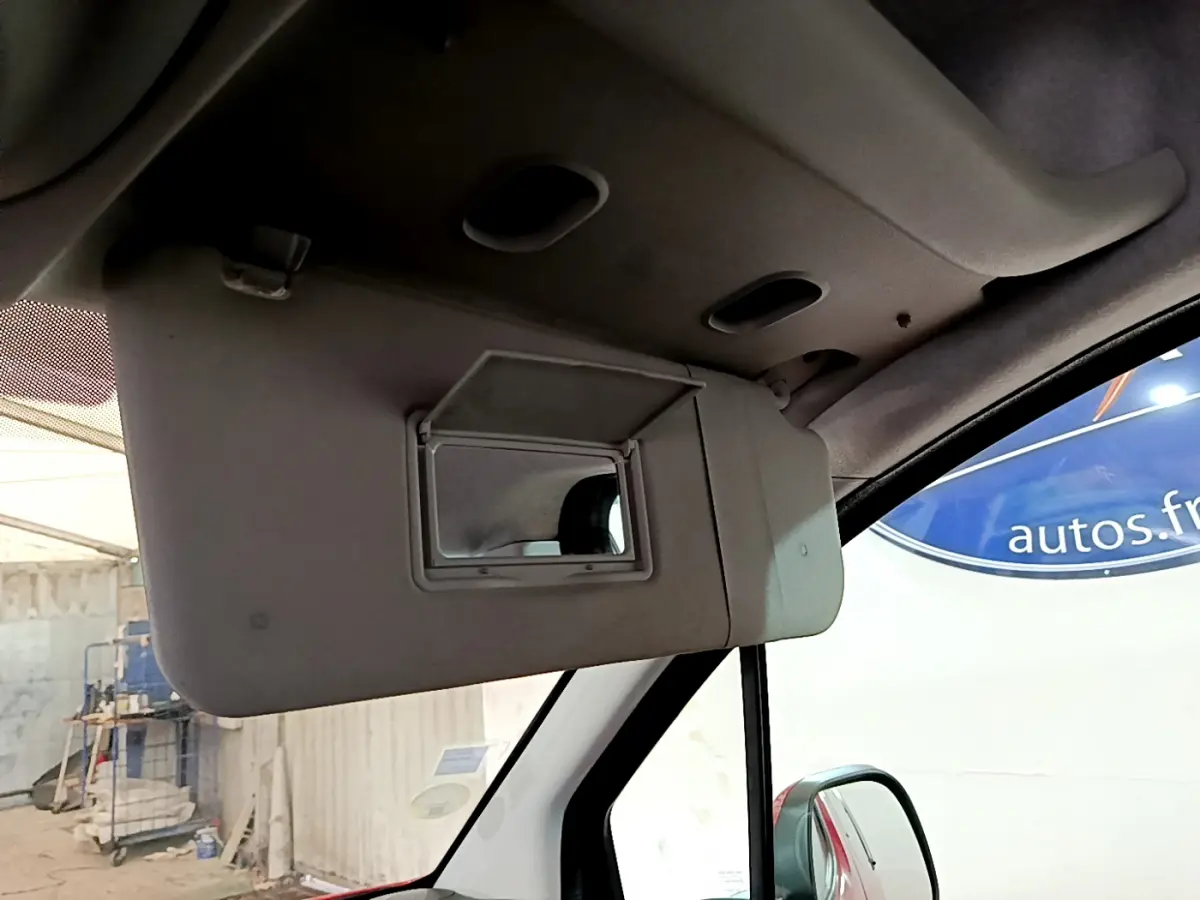 Miroir de courtoisie ouvert côté conducteur dans l'habitacle d'un Citroën Berlingo rouge 2016, vue intérieure rapprochée.