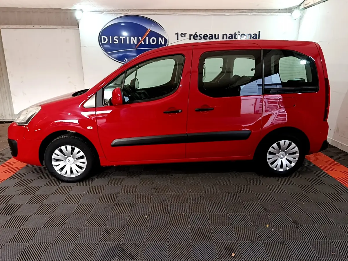 Profil droit d'un Citroën Berlingo rouge de 2016, version BlueHDi 75 BVM Feel, dans un showroom intérieur.