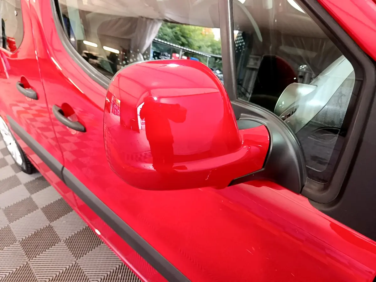 Gros plan sur le rétroviseur côté conducteur rouge d'un Citroën Berlingo 2016, avec portières et poignées visibles.