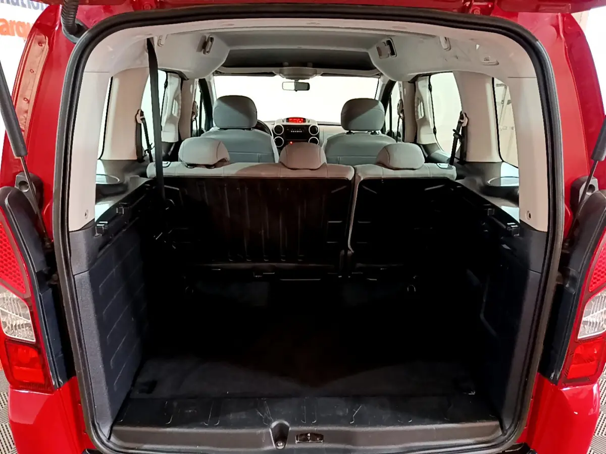 Vue arrière du coffre ouvert du Citroën Berlingo rouge 2016, montrant l'espace intérieur et la banquette arrière.