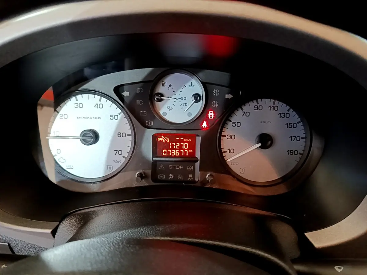 Vue rapprochée du tableau de bord du Citroën Berlingo rouge 2016, affichant compte-tours, vitesse et témoins lumineux allumés.