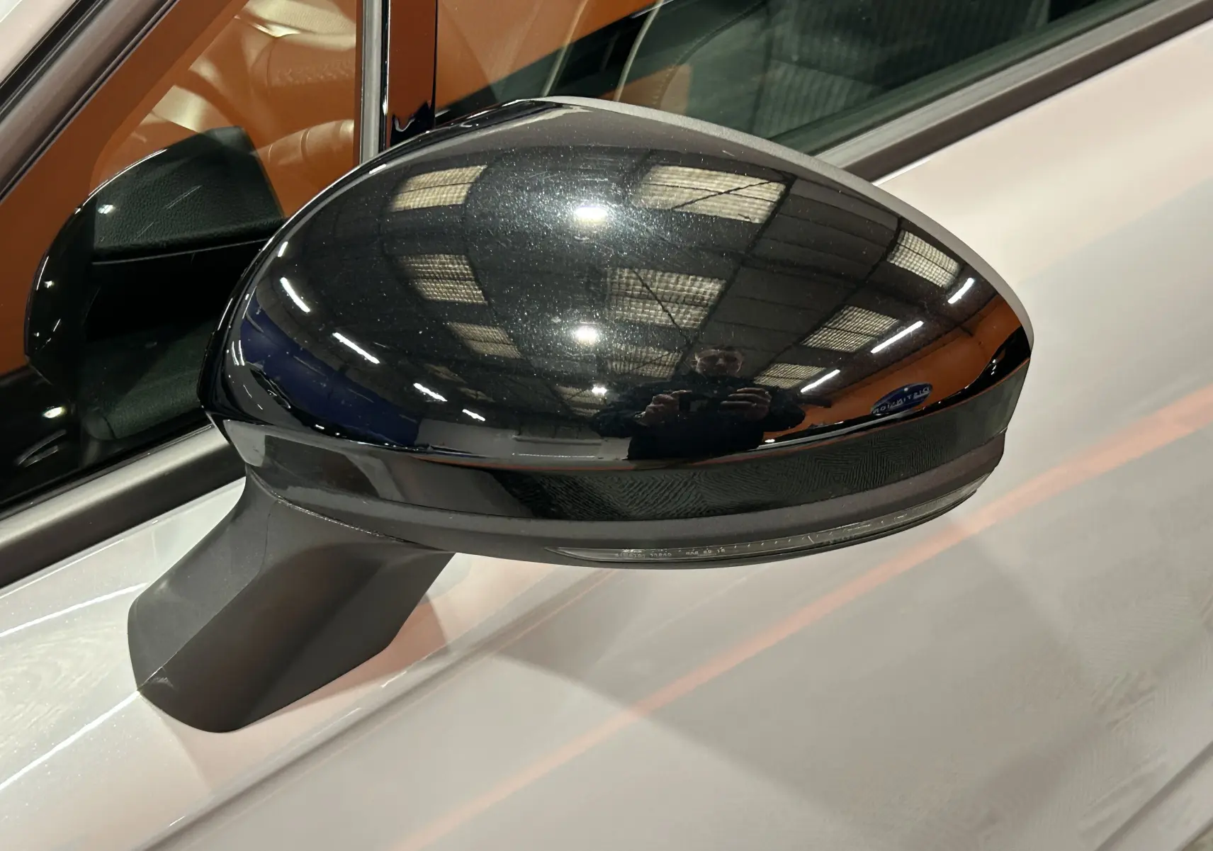 Rétroviseur côté gauche noir brillant sur Renault Clio V gris Rafale Métal, vue rapprochée sur la portière avant.