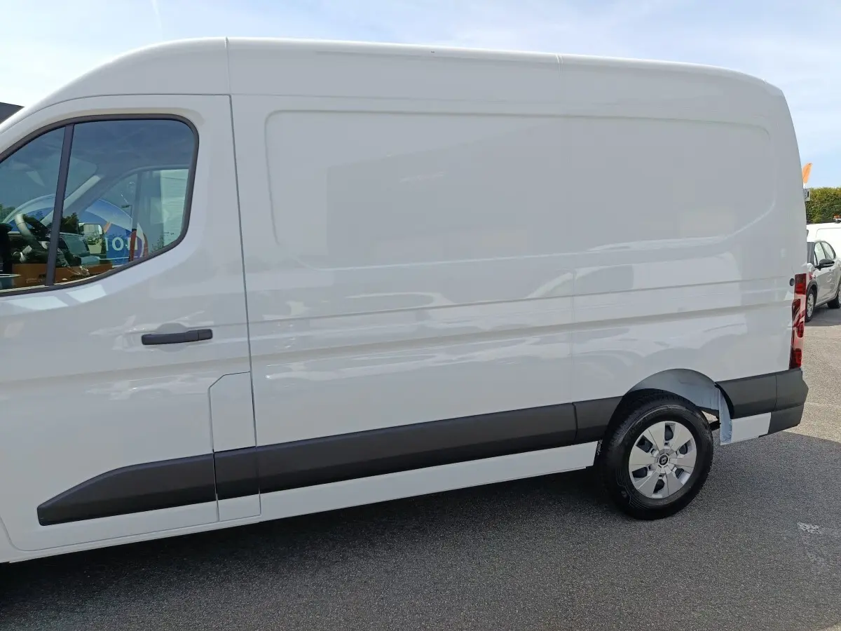 Vue de profil côté droit d’un utilitaire Renault Master blanc avec porte latérale coulissante et jantes acier.