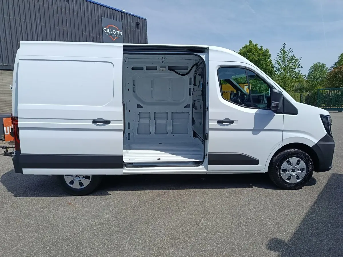Vue latérale droite d’un Renault Master blanc 2025 avec porte coulissante ouverte montrant l’espace de chargement vide.