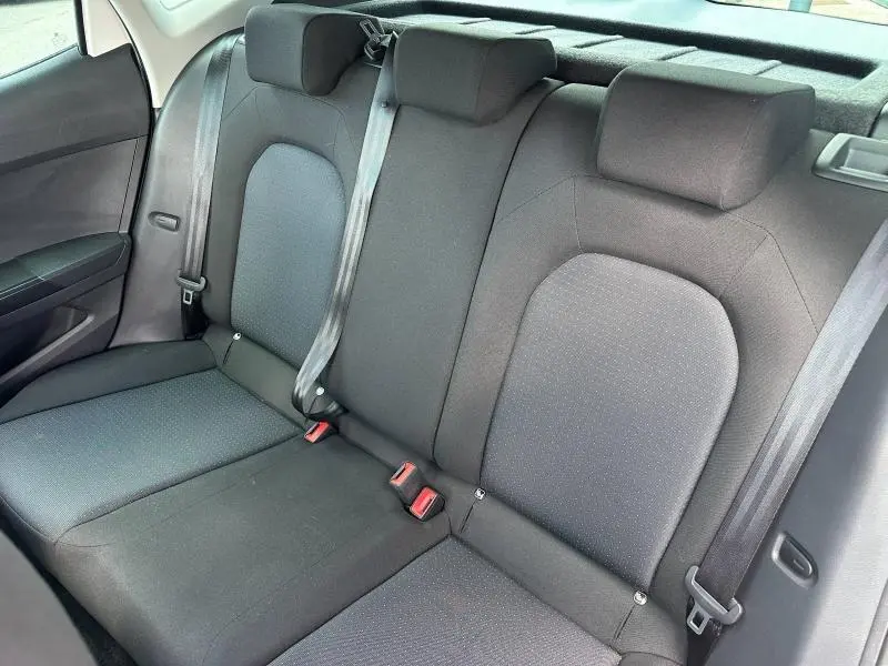 Vue intérieure de la banquette arrière grise du SEAT Arona 2025, avec ceintures de sécurité et appuie-têtes visibles.