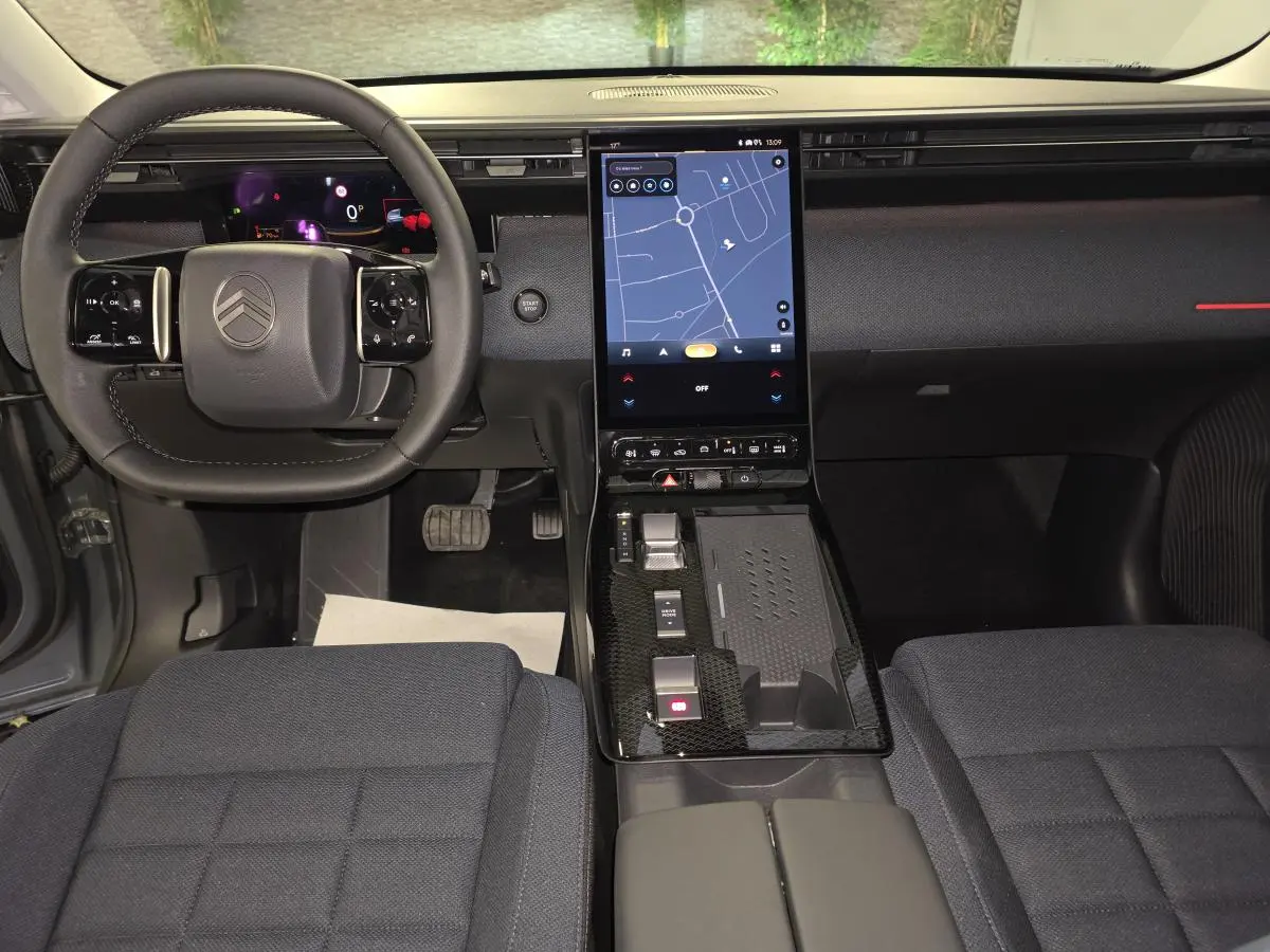 Vue intérieure avant du Citroën C5 Aircross 2026, tableau de bord noir avec écran tactile vertical et volant multifonctions.