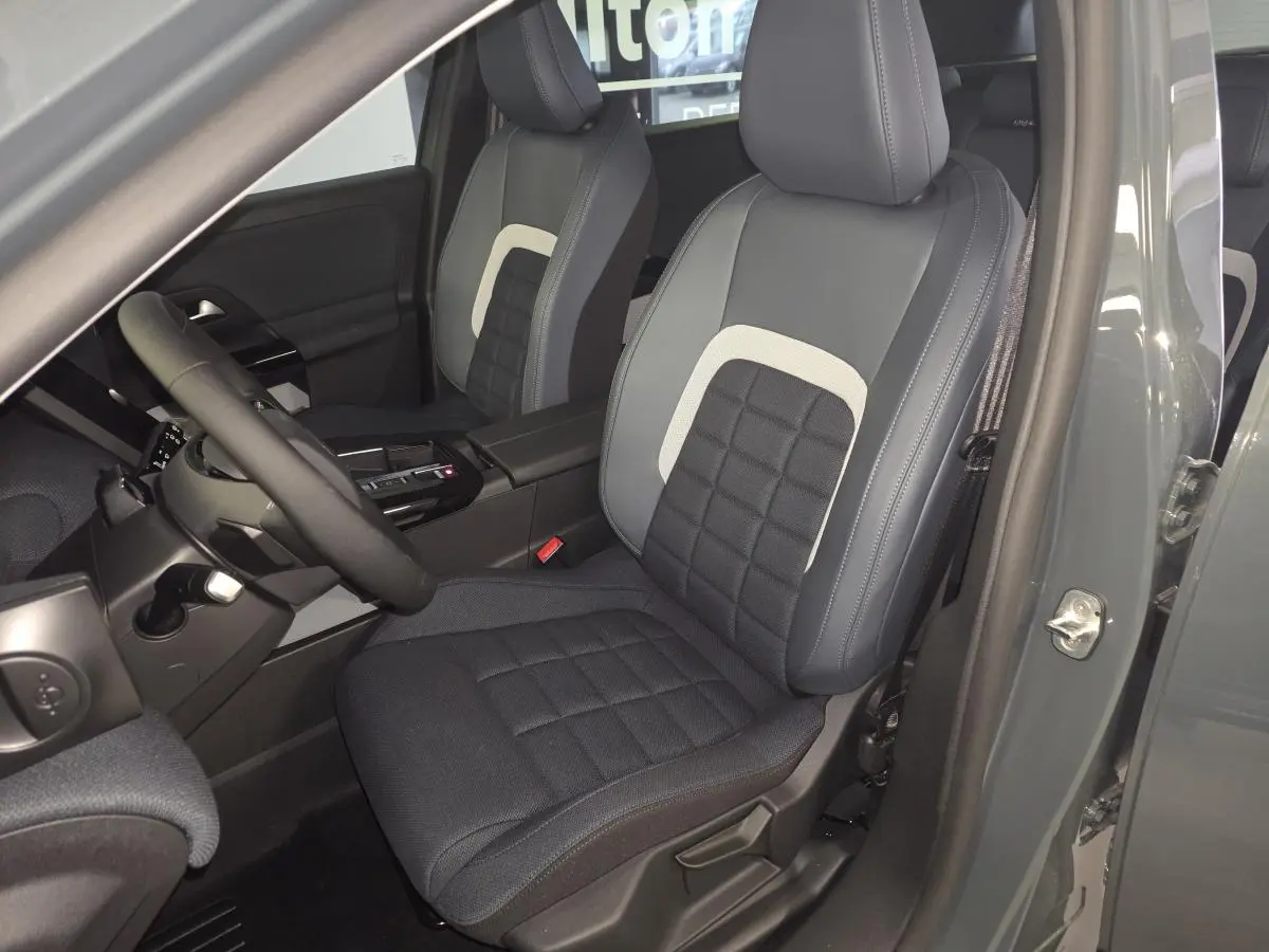 Vue intérieure côté conducteur du Citroën C5 Aircross 2026, sièges tissu bleu avec insert clair et volant multifonctions.