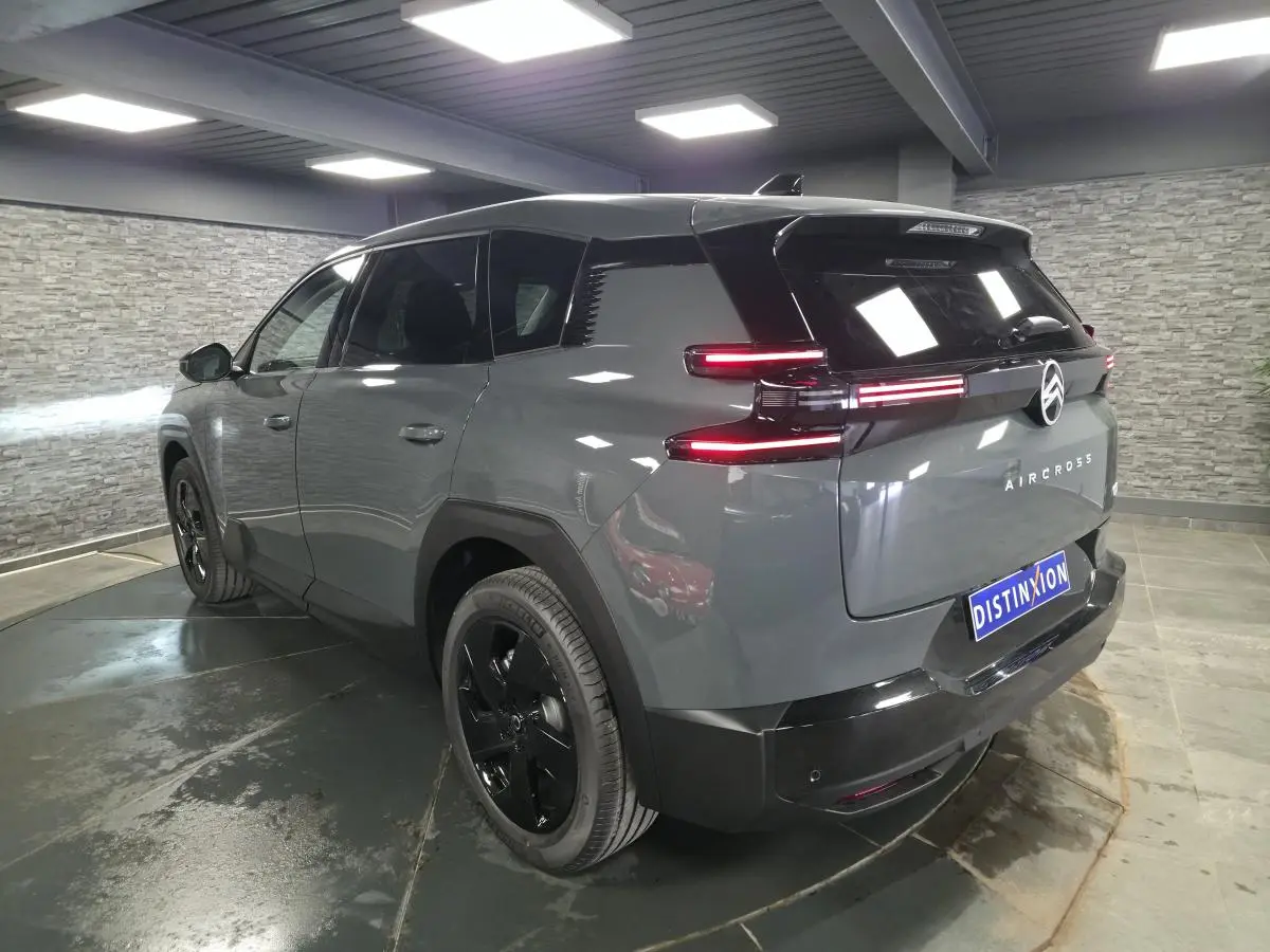 Vue 3/4 arrière droite du Citroën C5 Aircross gris métallisé avec feux arrière LED et jantes noires.